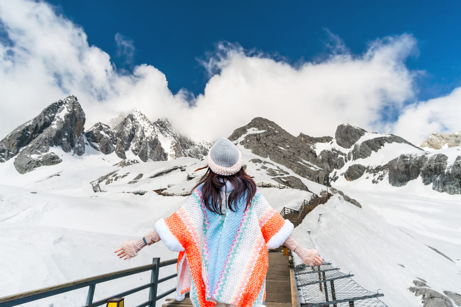 mujer vista de espaldas y frente a ella montañas nevadas